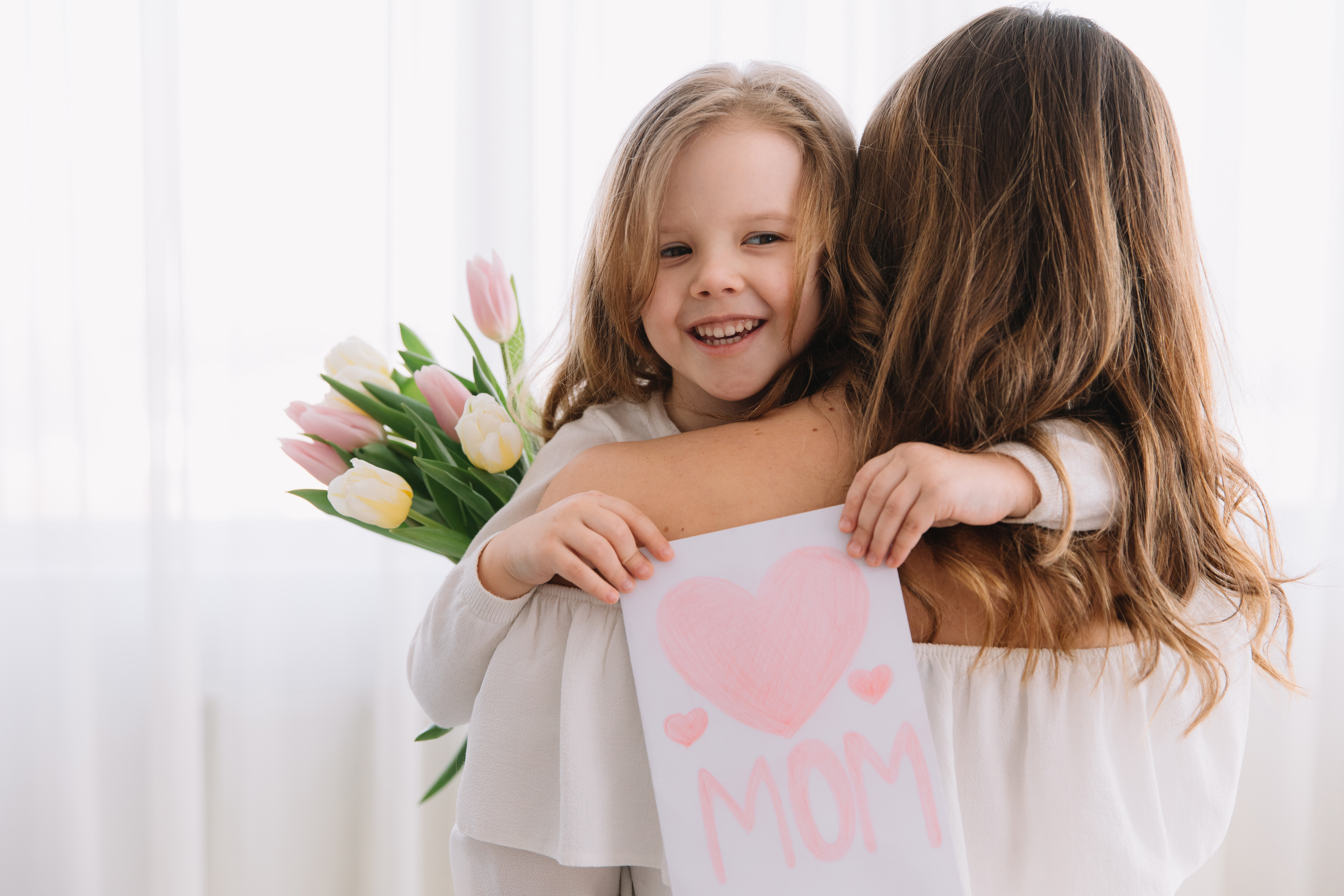 Happy mother's day. Child daughter congratulates moms and gives
